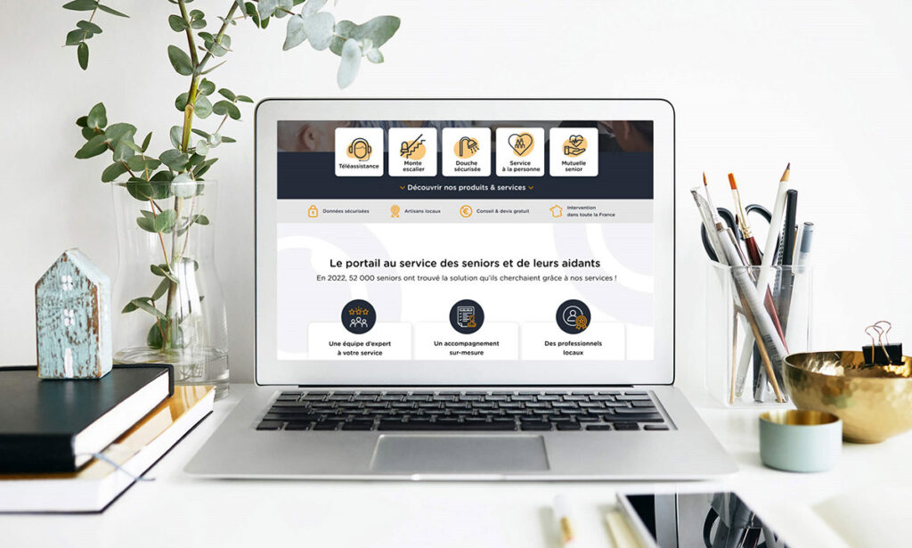 Ordinateur posé sur un bureau avec une page du site internet Bonjour senior. 
