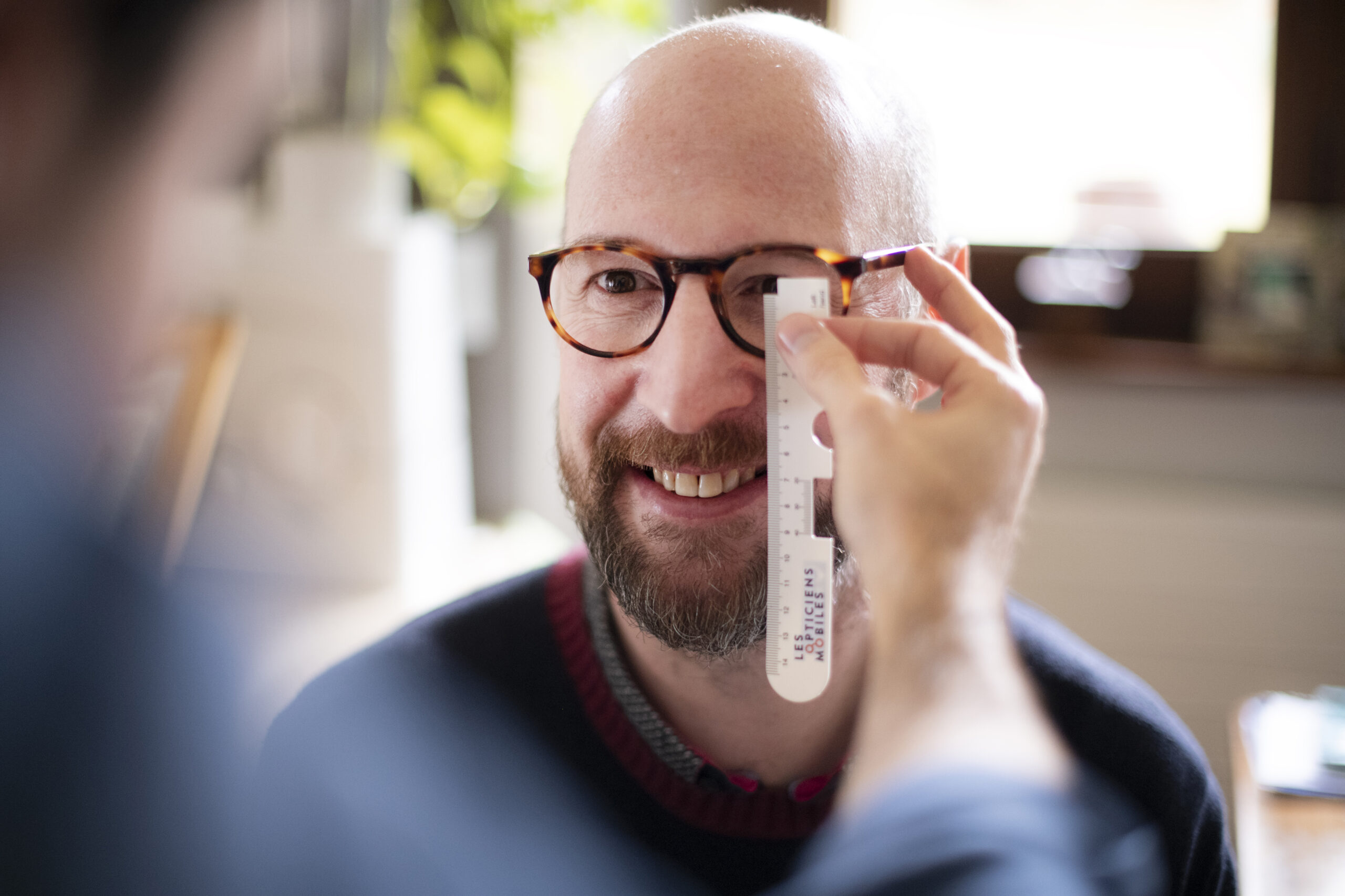 Opticien à domicile vérifie la vue du client en se déplaçant chez lui