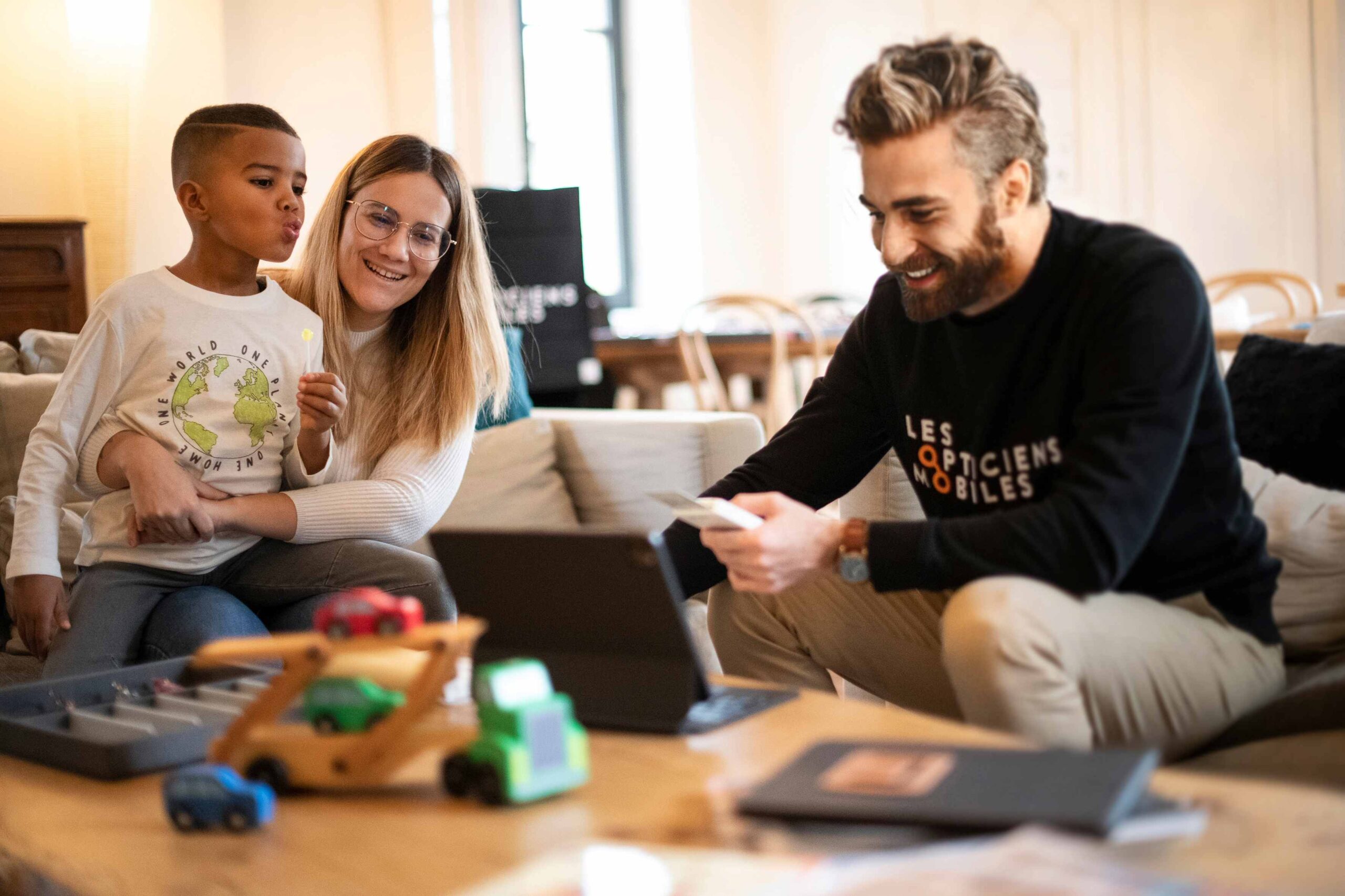 Opticien à domicile réalisant un bilan de vue avec une famille sur leur lieu de vie. Services d'optique à domicile pour enfants et adultes