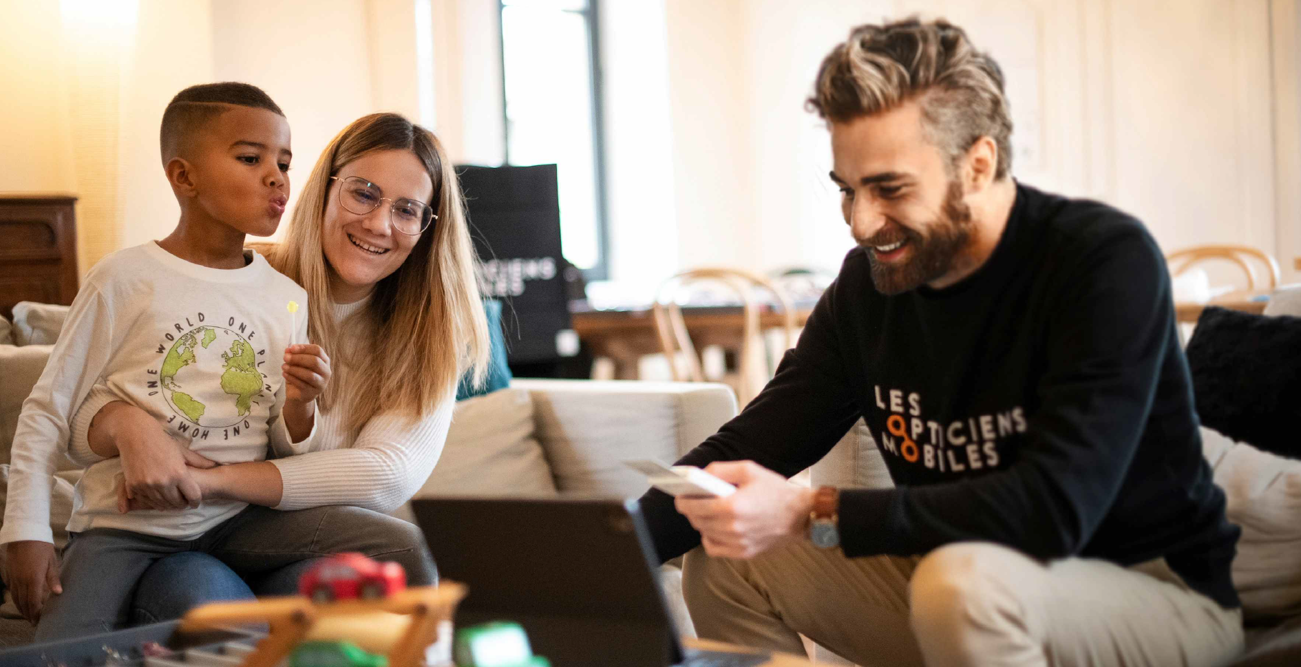 Opticien à domicile réalisant un bilan de vue avec une famille sur leur lieu de vie. Services d'optique à domicile pour enfants et adultes